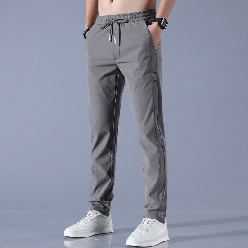 Grijze herenbroek, lente-zomer casual stijl, ademend en slank ontwerp, met elastische tailleband en trekkoord, geschikt voor sport en vrije tijd.